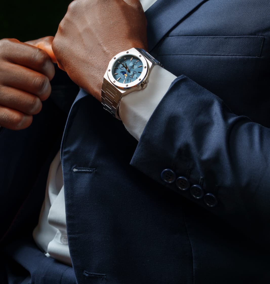Signature Moonphase on the wrist, worn with a navy suit